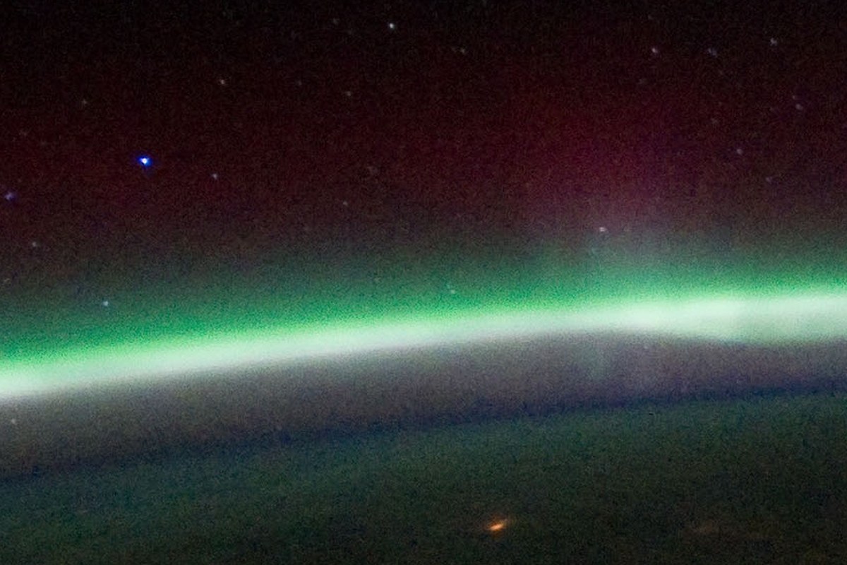 A green aurora curtain above a starfield