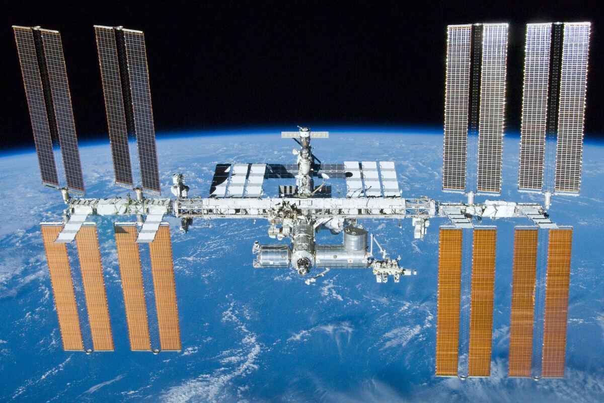 A bright satellite trail streaking across a starfield